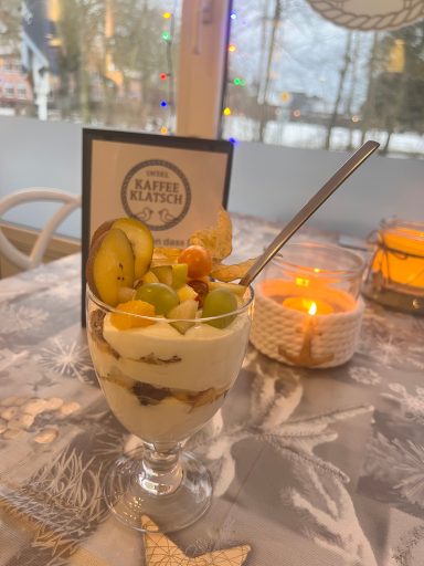 Fruchtiges Parfait mit Joghurt, Granola und verschiedenen frischen Früchten im Glas.